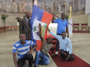Haitianos aproveitam final da missa para posar com a bandeira nacional. Crédito: Rodrigo Borges Delfim